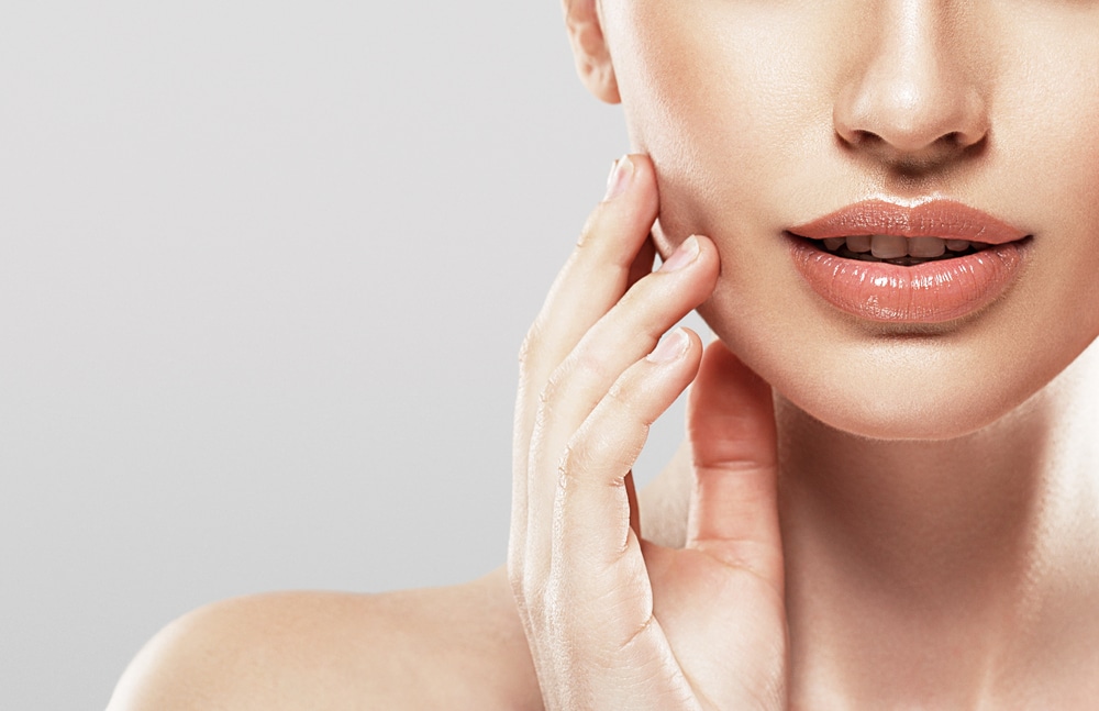 Woman with natural-looking full lips after dermal filler treatment.